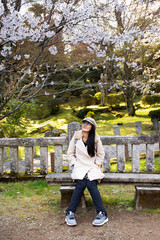 Fototapeta premium Travelers thai women walking and posing portrait for take photo with Sakura tree in Naritasan plum garden of Narita public park at Chiba Prefecture in Tokyo, Japan
