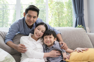 Asian family father, mother and son smiling together in living room, happy family concept