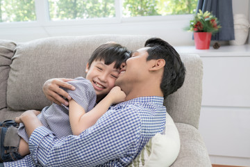 Asian family father and son playing together in living room, happy family concept