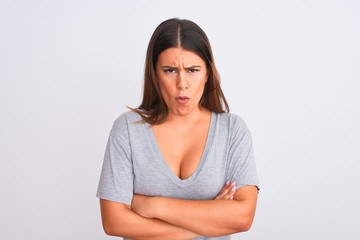 Portrait of beautiful young woman standing over isolated white background skeptic and nervous, disapproving expression on face with crossed arms. Negative person.