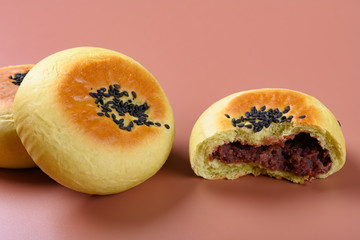 side view cut out red bean paste cake with some complete ones on a brown background