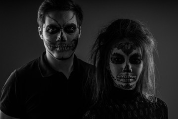 Black and white portrait of a guy and a girl with face art as a zombie for . Halloween. Hallowmas
