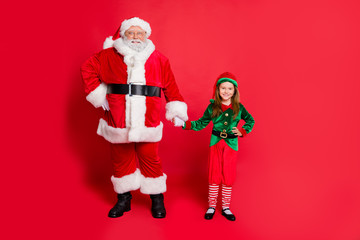 Full length photo of charming santa elf in hat headwear holding hands ready to enjoy christmas time...