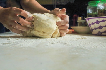 woman's hands knead pizza dough