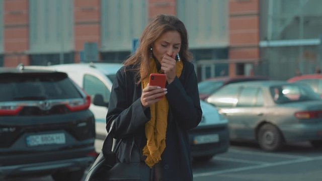Young woman stand use phone feel sick coughs at outdoor fever cold allergy city beautiful disease female nose sneeze smartphone cellphone runny tissue illness influenza cough district slow motion