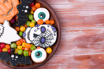 Halloween party content. Halloween gingerbread cookies on a wood background.