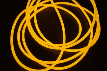 Bright orange luminous wire, twisted light wire, cable. Different shapes and images of еlectroluminescent wires with different twists, juicy el wire.