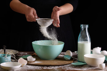 The process of making cupcakes, coating a cream from a pastry bag in the hands of a pastry chef.