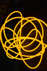 Bright orange luminous wire, twisted light wire, cable. Different shapes and images of еlectroluminescent wires with different twists, juicy el wire.