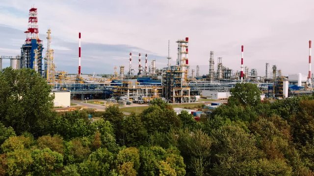 Oil refinery Lotos company, Gdansk, Poland, ascending approaching shot over the trees