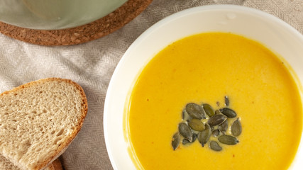 pumpkin cream soup with pumpkin seeds and bread