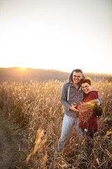 portrait of loving middle-aged couple in warm clothes hugging in the autumn park at sunset in selective focus.