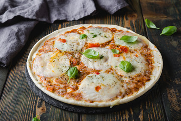 Thin pizza with mozzarella and basil