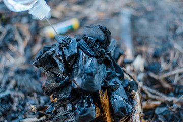 Barbecue coals. Pouring liquid for ignition.