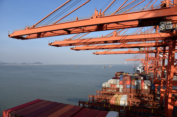 View on the container terminal and gantry cranes loading containers on the cargo ship in the port...