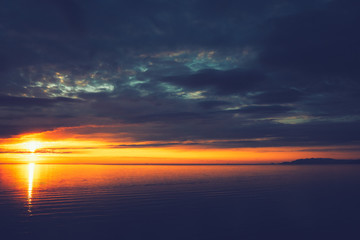 Aerial breathtaking sunset, view from a drone, sun going down in the horizon, amazing light