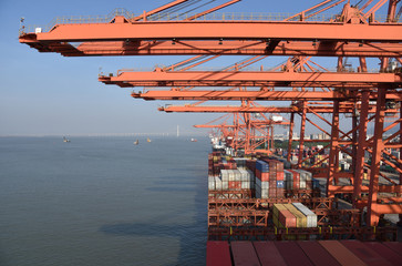 View on the container terminal and gantry cranes loading containers on the cargo ship in the port...