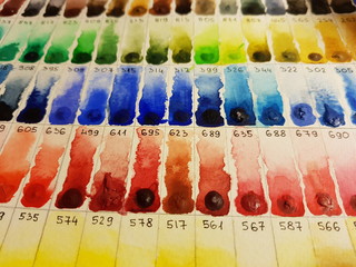 All watercolor palette with a samples and numbers of paint on paper.