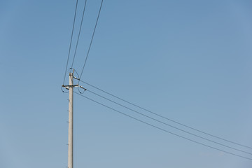 Close-up of concrete cement poles and wires against sky clouds background