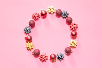Christmas ornaments forming a circle with a pink background