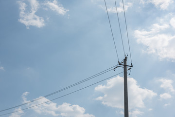 Close-up of concrete cement poles and wires against sky clouds background