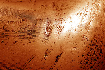 Part of bronze sculpture close-up in orange tone.