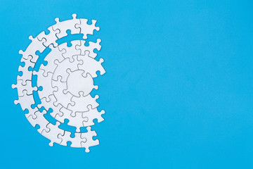 White jigsaw pieces on a blue background, Copy space, Concept image of unfinished task.  missing jigsaw puzzle pieces and business concept with a puzzle piece missing.