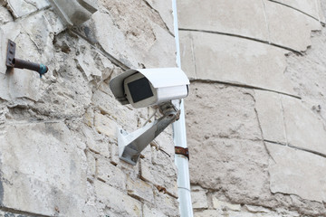 old white secure camera on the wall