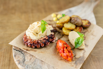Roasted octopus BBQ with Baked potato. Wooden plate. Restaurant menu