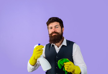 Male janitor with cleaning equipments. Professional cleaning man in uniform. Bearded man in uniform, rubber gloves with cleaning products. Domestic service cleaner man with rag and cleaner spray.