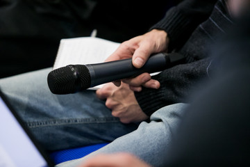 Press officer of a company giving interview to journalist with a microphone