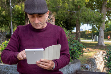 Fototapeta premium Middle Age Man Playing With Tablet in The Park