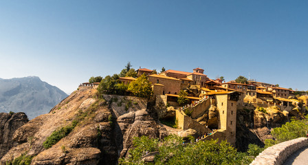 Fototapeta premium Monastery Meteora Greece. Stunning panoramic landscape. View of mountains and green forest against epic blue sky with clouds. UNESCO heritage object.
