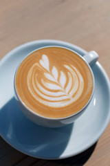 a cup of coffee stands on a wooden table. 