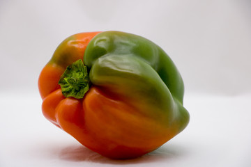 orange-green bell peppers on a white background