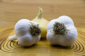 Garlic and onion on wooden background. Selective focus.