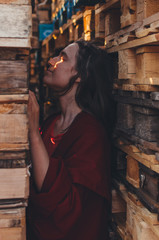 Woman in red posing near wooden pallets. Eco concept