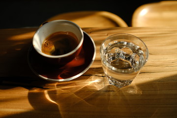 black coffee in a cup and a glass with water