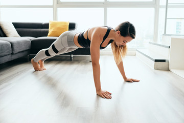 Fototapeta na wymiar Woman Practicing Yoga At Home Doing Sun Salutation Routine
