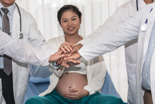 The team of doctors and female patients Who are pregnant, Join hands together to show confidence And cooperation in the best care of patients, to maternity and health care concept.