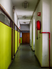 Corridor of an old industrial facility with cabinet doors and fire extinguisher equipment