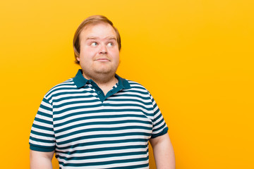 young big size man looking puzzled and confused, wondering or trying to solve a problem or thinking...