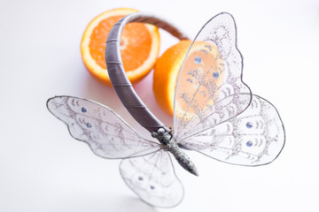 Light as butterfly. Butterfly decoration in front of orange.