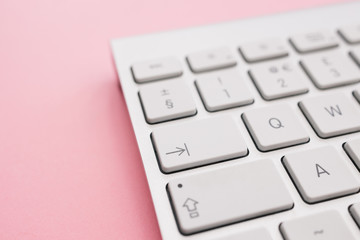 Computer keyboard minimal home office bright pink color background top view