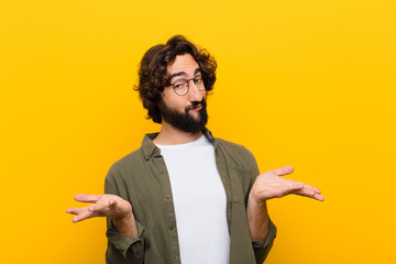 young crazy man feeling puzzled and confused, unsure about the correct answer or decision, trying...