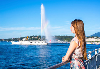 woman enjoying her vacation, standing by the fence at the sea