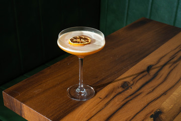 un cocktail in coppa con una fetta d'arancia essiccata