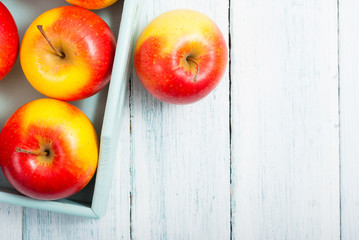 apples at blue tray, white wood table