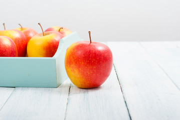 apples at blue tray, white wood table