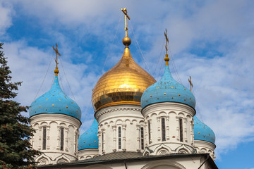 Fototapeta na wymiar Golden and blue domes of an Orthodox church on a background of blue sky with white clouds